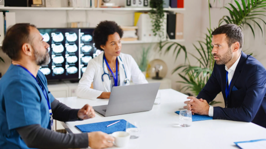 Three health care workers sitting at a table talking