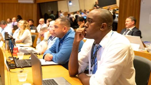 Students sitting in a classroom, listening intently