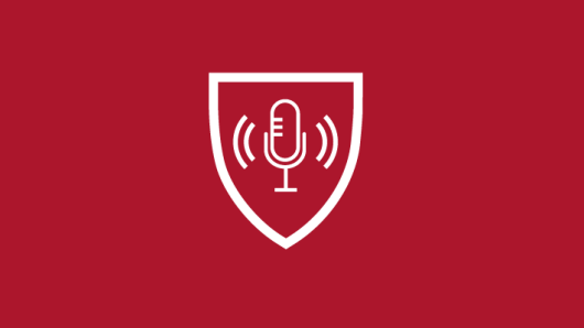 microphone icon within a shield icon on a crimson background