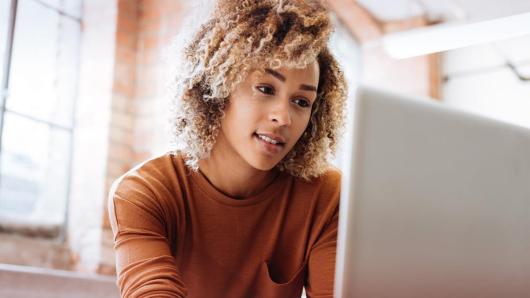 Woman enthusiastically looking at a computer screen.