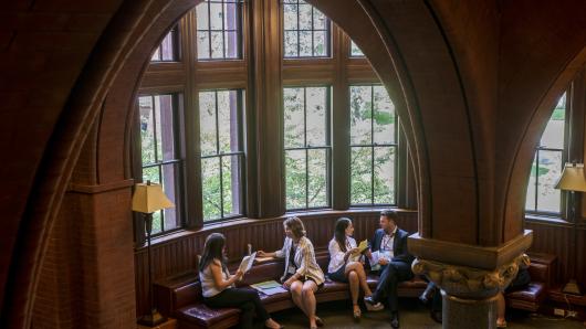 Master Class participants engage in negotiation role plays in front of windows at Harvard Law School.