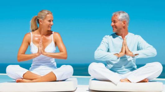 A man and woman practicing yoga.