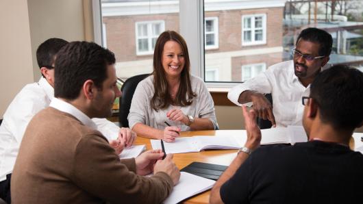 Executives enjoy a working meeting inside an HBS conference room