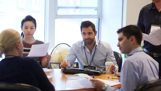 Two female and two male executives in discussion around a table