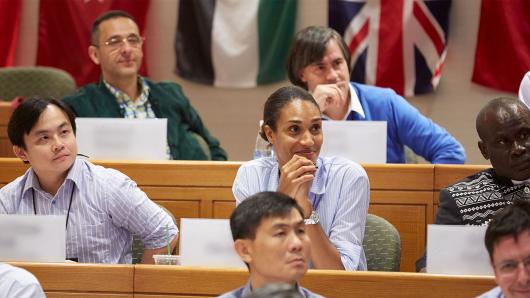 A diverse group of executives sitting in an executive education classroom