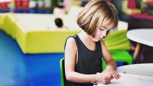 A girl writing at a desk.