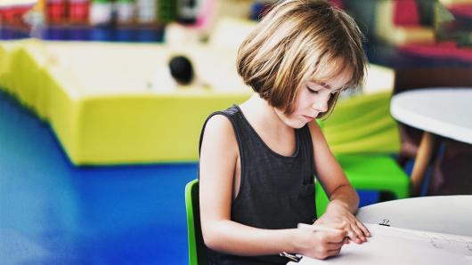 A girl writing at a desk.