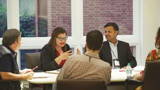 Female and male executives in discussion around a table